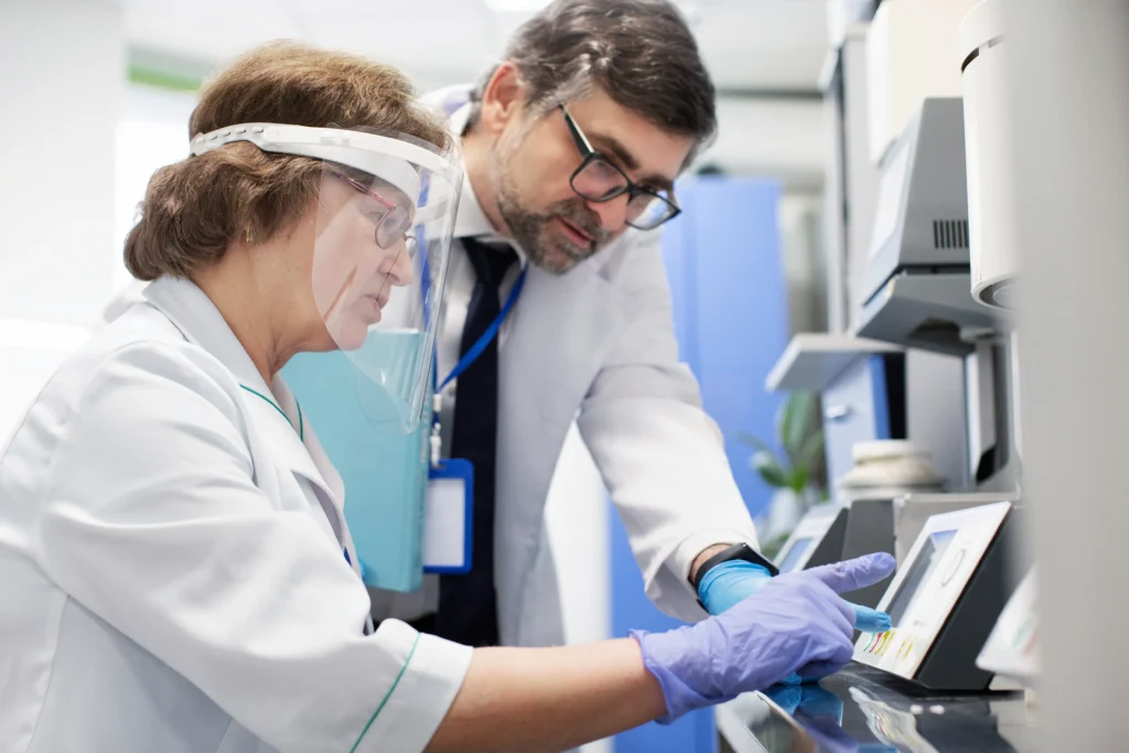 Specjaliści wykonujący analizy chemiczne przy nowoczesnej aparaturze laboratoryjnej.